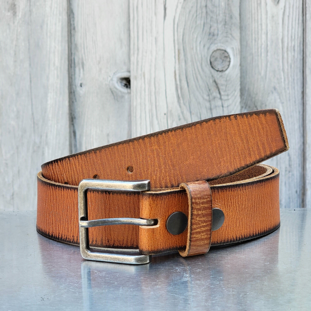 The Mountain women's leather belt with charred edges in tan